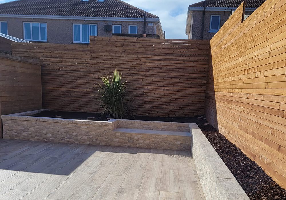 Wood effect patio with flower bed around the perimeter